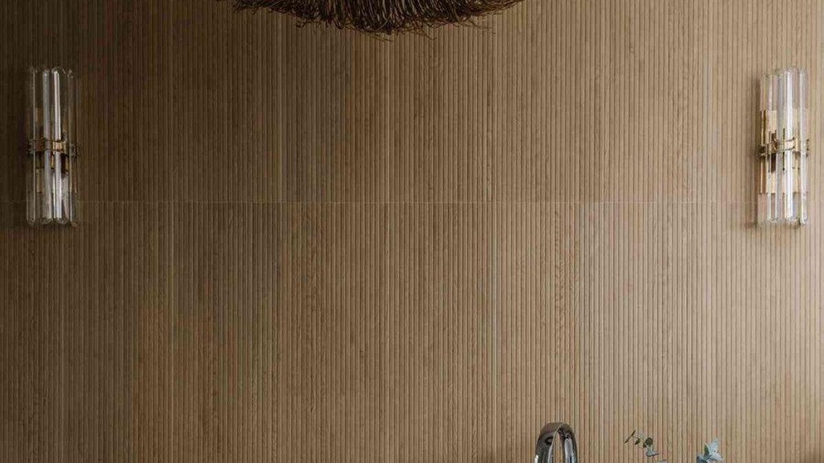 Walk-in shower with glass panel, hexagon floor tiles and a tiled niche