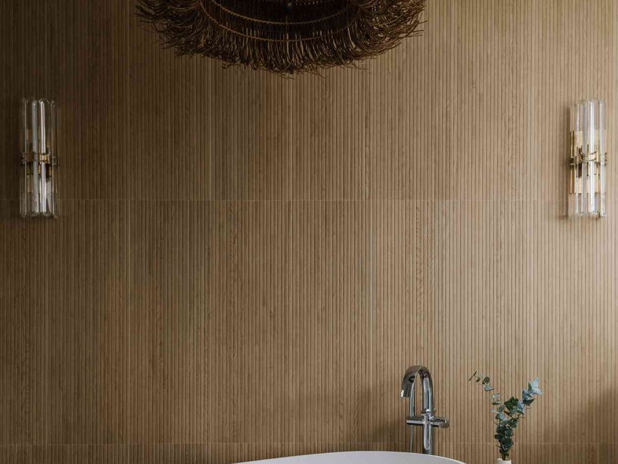 Remodelled bathroom with a freestanding tub and warm wood panelling